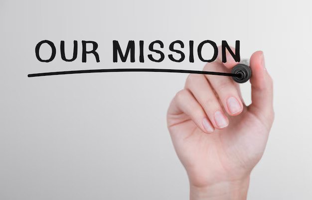 Woman's hand writing 'Our Mission'